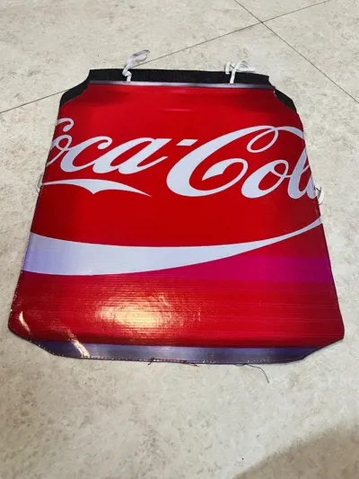 Coca Cola can costume board laid flat showing the red wrapper, white swoosh and ties