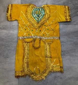Yellow Hanuman fancy dress laid flat — mustard gold tunic with turquoise beaded yoke and tasselled gold belt