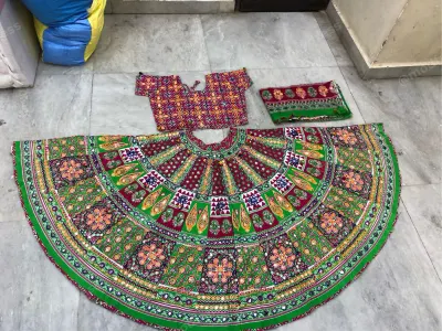 Green printed Gujarati garba chaniya choli laid flat — concentric paisley and floral bands with a maroon yoke and printed choli