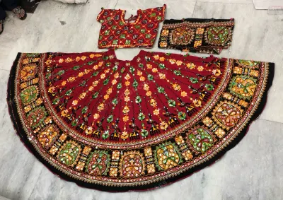 Maroon dandiya lehenga laid flat — Kutchi floral embroidery with black border, matching embroidered choli and dupatta