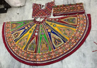 Multicolour garba chaniya choli laid flat — triangular mirror-work panels in green, blue, yellow and red with a maroon border